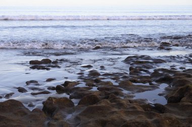 Tenerife Adası, İspanya 'nın güneyindeki El Medano' da kumlu sahilde gün batımında dinleniyorum.