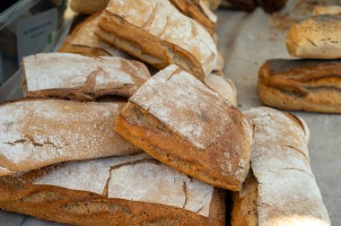 Doğal mayayla yapılan ekşi hamurlu biyolojik ekmek ve Provence, Fransa 'da pazarda satılmak üzere odun sobasında pişirildi.