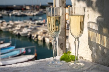 Yazın doğum günü kutlaması iki bardak Fransız şampanyası köpüklü şarap ve renkli balıkçı tekneleriyle Cassis, Provence, Fransa 'daki eski limanda.