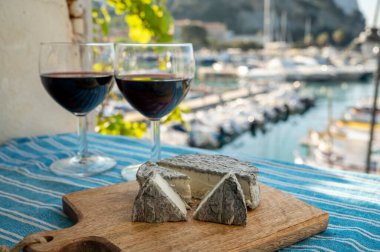 Kırmızı Provencal şarabı ve peynirli yaz partisi terasta eski balıkçıların limanı manzaralı Cassis, Provence, Fransa 'da renkli teknelerle