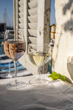 Cassis şarapları ve beyaz şarap üreten bölge, Cassis, Provence, Fransa 'daki renkli teknelerle eski balıkçıların limanı manzaralı terasta servis ediliyor.