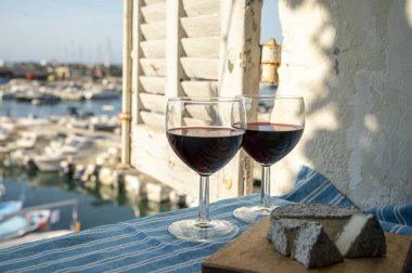 Kırmızı Provencal şarabı ve peynirli yaz partisi terasta eski balıkçıların limanı manzaralı Cassis, Provence, Fransa 'da renkli teknelerle