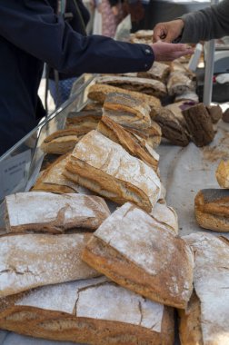 Doğal mayayla yapılan ekşi hamurlu biyolojik ekmek ve Provence, Fransa 'da pazarda satılmak üzere odun sobasında pişirildi.
