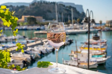Açık terasta sunulan Rose Provencal şarabı Cassis, Provence, Fransa 'daki eski balıkçıların limanında renkli teknelerle servis ediliyor.