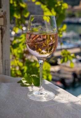 Açık terasta sunulan Rose Provencal şarabı Cassis, Provence, Fransa 'daki eski balıkçıların limanında renkli teknelerle servis ediliyor.