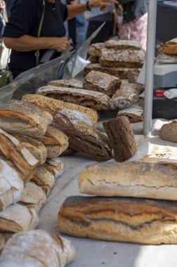 Doğal mayayla yapılan ekşi hamurlu biyolojik ekmek ve Provence, Fransa 'da pazarda satılmak üzere odun sobasında pişirildi.