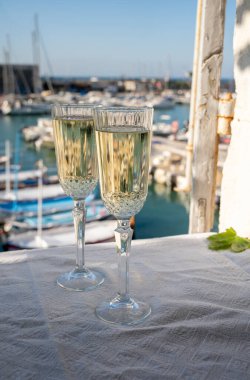 Yazın doğum günü kutlaması iki bardak Fransız şampanyası köpüklü şarap ve renkli balıkçı tekneleriyle Cassis, Provence, Fransa 'daki eski limanda.