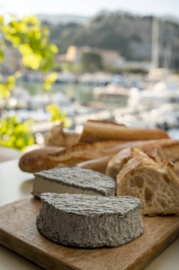 Fransız keçi peyniri selles-sur-cher ve taze kruvasan Cassis, Provence, Fransa 'nın limanındaki teknelerde servis ediliyor. Peynir tatma, yakın çekim.