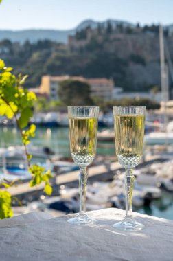 Yazın doğum günü kutlaması iki bardak Fransız şampanyası köpüklü şarap ve renkli balıkçı tekneleriyle Cassis, Provence, Fransa 'daki eski limanda.