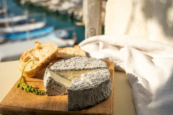 Fransız keçi peyniri selles-sur-cher ve taze kruvasan Cassis, Provence, Fransa 'nın limanındaki teknelerde servis ediliyor. Peynir tatma, yakın çekim.