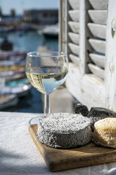 Fransız keçi peyniri crottin ve selles-sur-cher Cassis, Provence, Fransa 'nın limanındaki teknelerde sunuldu. Peynir, bir bardak kuru beyaz şarapla tattı.