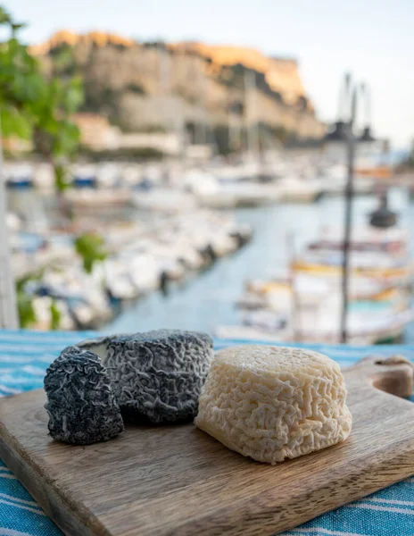 Fransız keçi peyniri crottin beyaz ve siyah Cassis, Provence, Fransa limanındaki teknelerde servis ediliyor.