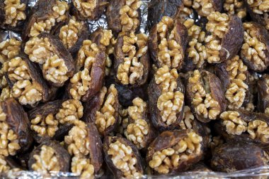 Turkish or arabic sweet dessert, ripe dried dadels with walnuts sweetened with syrup or honey, close up
