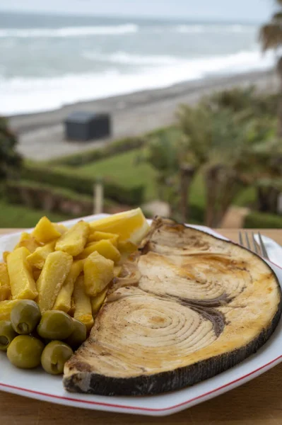 海の見えるビーチカフェで提供されるシーフード料理 メカジキやスパダのグリルステーキは フランスのジャガイモと緑のオリーブで提供され クローズアップ — ストック写真