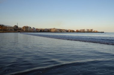 Tenerife Adası, İspanya 'nın güneyindeki El Medano' da kumlu sahilde gün batımında dinleniyorum.