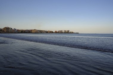Tenerife Adası, İspanya 'nın güneyindeki El Medano' da kumlu sahilde gün batımında dinleniyorum.