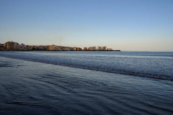 Tenerife Adası, İspanya 'nın güneyindeki El Medano' da kumlu sahilde gün batımında dinleniyorum.