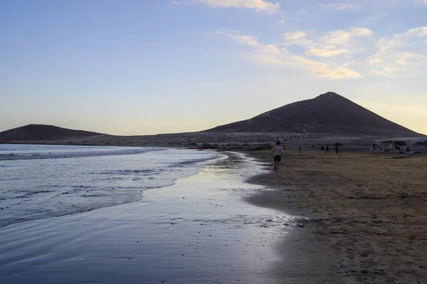 Tenerife Adası, İspanya 'nın güneyindeki El Medano' da kumlu sahilde gün batımında dinleniyorum.