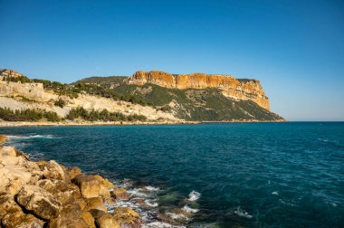 Fransa 'nın güneyinde nisan ayında güneşli bir gün, Cassis, Provence, Fransa' da tekne ve renkli binalarla eski balıkçıların limanına bakıyor.