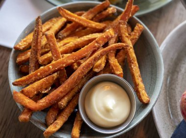 Mayonez soslu kızarmış patates cipsi ile servis edilen bir kase.