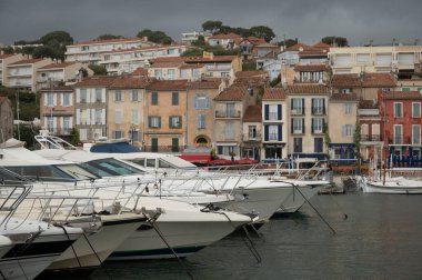 Fransa 'nın güneyinde nisan ayında yağışlı bir gün, Cassis, Provence, Fransa' da eski balıkçıların limanına tekne ve renkli binalarla bakmak