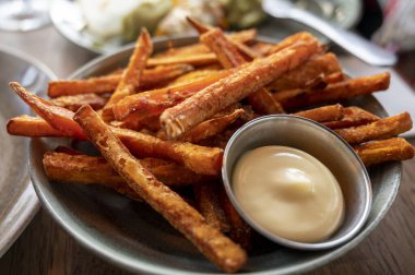 Bowl with tasty deep fried sweet potato chips served with mayonnaise sauce