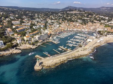 Kumsalda panoramik hava manzarası, mavi deniz, uçurumlar, evler, sokaklar ve Cassis, Provence, Fransa 'da deniz feneri olan eski balıkçıların limanı bulutlu bir günde
