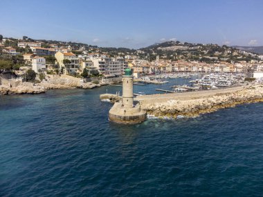 Kumsalda panoramik hava manzarası, mavi deniz, uçurumlar, evler, sokaklar ve Cassis, Provence, Fransa 'da deniz feneri olan eski balıkçıların limanı bulutlu bir günde