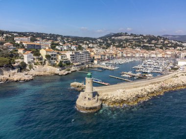 Kumsalda panoramik hava manzarası, mavi deniz, uçurumlar, evler, sokaklar ve Cassis, Provence, Fransa 'da deniz feneri olan eski balıkçıların limanı bulutlu bir günde