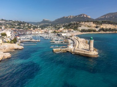 Kumsalda panoramik hava manzarası, mavi deniz, uçurumlar, evler, sokaklar ve Cassis, Provence, Fransa 'da deniz feneri olan eski balıkçıların limanı bulutlu bir günde