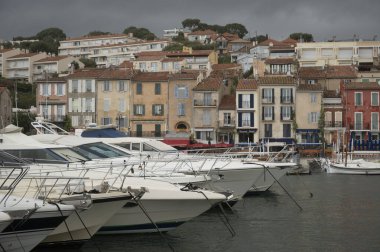 Fransa 'nın güneyinde nisan ayında yağışlı bir gün, Cassis, Provence, Fransa' da eski balıkçıların limanına tekne ve renkli binalarla bakmak