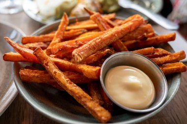 Bowl with tasty deep fried sweet potato chips served with mayonnaise sauce