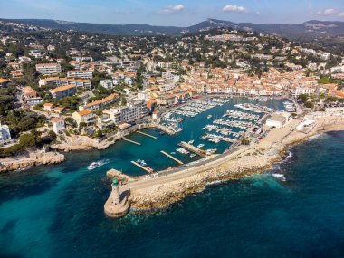 Kumsalda panoramik hava manzarası, mavi deniz, uçurumlar, evler, sokaklar ve Cassis, Provence, Fransa 'da deniz feneri olan eski balıkçıların limanı bulutlu bir günde