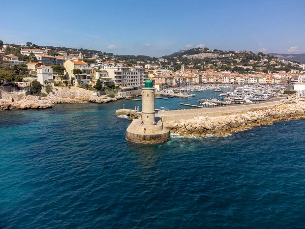 Kumsalda panoramik hava manzarası, mavi deniz, uçurumlar, evler, sokaklar ve Cassis, Provence, Fransa 'da deniz feneri olan eski balıkçıların limanı bulutlu bir günde