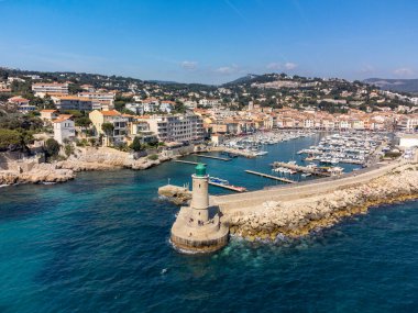 Kumsalda panoramik hava manzarası, mavi deniz, uçurumlar, evler, sokaklar ve Cassis, Provence, Fransa 'da deniz feneri olan eski balıkçıların limanı bulutlu bir günde