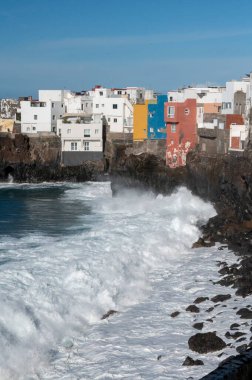Puerto de la Cruz, Tenerife, İspanya 'nın Kanarya Adaları yakınlarındaki küçük balıkçı köyündeki renkli evler ve siyah lav kayalıklarına bakın.