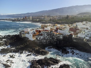Puerto de la Cruz, Tenerife, Kanarya Adaları yakınlarındaki küçük balıkçı köyünde renkli evlere ve siyah lav kayalarına hava manzarası