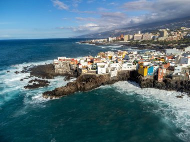 Puerto de la Cruz, Tenerife yakınlarındaki Punta Brava adlı küçük balıkçı köyünde renkli evler ve siyah lav kayaları üzerindeki hava manzarası, kışın İspanya 'da Kanarya Adaları