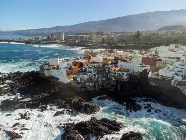 Puerto de la Cruz, Tenerife, Kanarya Adaları yakınlarındaki küçük balıkçı köyünde renkli evlere ve siyah lav kayalarına hava manzarası