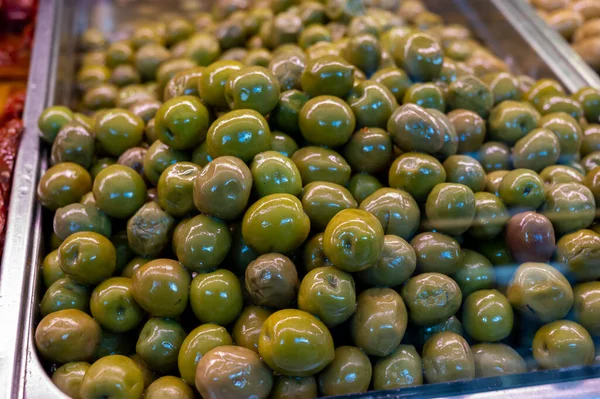 おいしい緑のオリーブは市場で閉じます 健康的な菜食主義者の食品の背景 — ストック写真