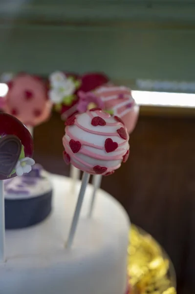 Food styling in bakery, wedding or happy valentine colorful lollypop candies decorated with chocolate hearts and flowers