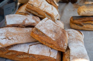 Doğal mayayla yapılan ekşi hamurlu biyolojik ekmek ve Provence, Fransa 'da pazarda satılmak üzere odun sobasında pişirildi.