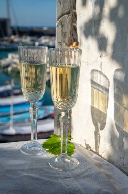 Yazın doğum günü kutlaması iki bardak Fransız şampanyası köpüklü şarap ve renkli balıkçı tekneleriyle Cassis, Provence, Fransa 'daki eski limanda.