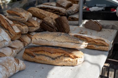 Doğal mayayla yapılan ekşi hamurlu biyolojik ekmek ve Provence, Fransa 'da pazarda satılmak üzere odun sobasında pişirildi.