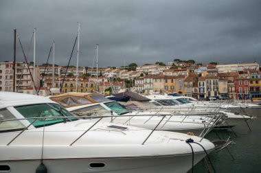 Fransa 'nın güneyinde nisan ayında yağışlı bir gün, Cassis, Provence, Fransa' da eski balıkçıların limanına tekne ve renkli binalarla bakmak