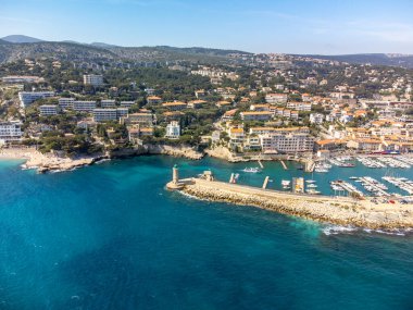 Kumsalda panoramik hava manzarası, mavi deniz, uçurumlar, evler, sokaklar ve Cassis, Provence, Fransa 'da deniz feneri olan eski balıkçıların limanı bulutlu bir günde