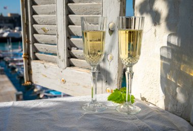 Yazın doğum günü kutlaması iki bardak Fransız şampanyası köpüklü şarap ve renkli balıkçı tekneleriyle Cassis, Provence, Fransa 'daki eski limanda.