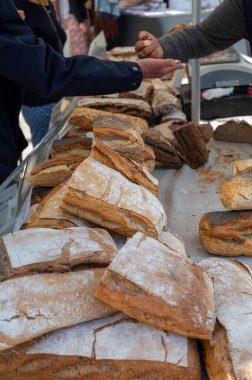 Doğal mayayla yapılan ekşi hamurlu biyolojik ekmek ve Provence, Fransa 'da pazarda satılmak üzere odun sobasında pişirildi.