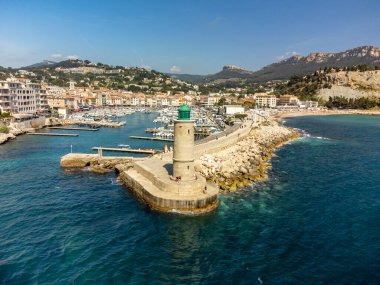 Kumsalda panoramik hava manzarası, mavi deniz, uçurumlar, evler, sokaklar ve Cassis, Provence, Fransa 'da deniz feneri olan eski balıkçıların limanı bulutlu bir günde