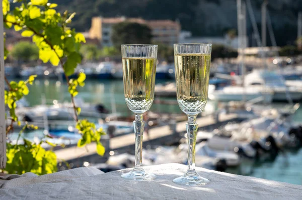 Yazın doğum günü kutlaması iki bardak Fransız şampanyası köpüklü şarap ve renkli balıkçı tekneleriyle Cassis, Provence, Fransa 'daki eski limanda.